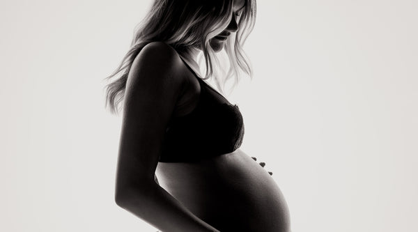Profile photo of a pregnant woman in her underwear. ©Janko Ferlic for Unsplash.