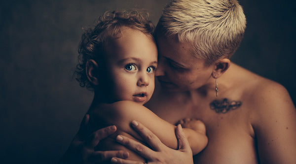 Naked shirtless woman holding her baby skin-to-skin ©Janko Ferlic for Unsplash. 